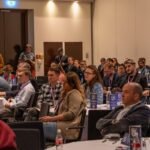 A diverse audience of professionals seated and listening attentively during a presentation at the Conversational AI & Customer Experience Summit.